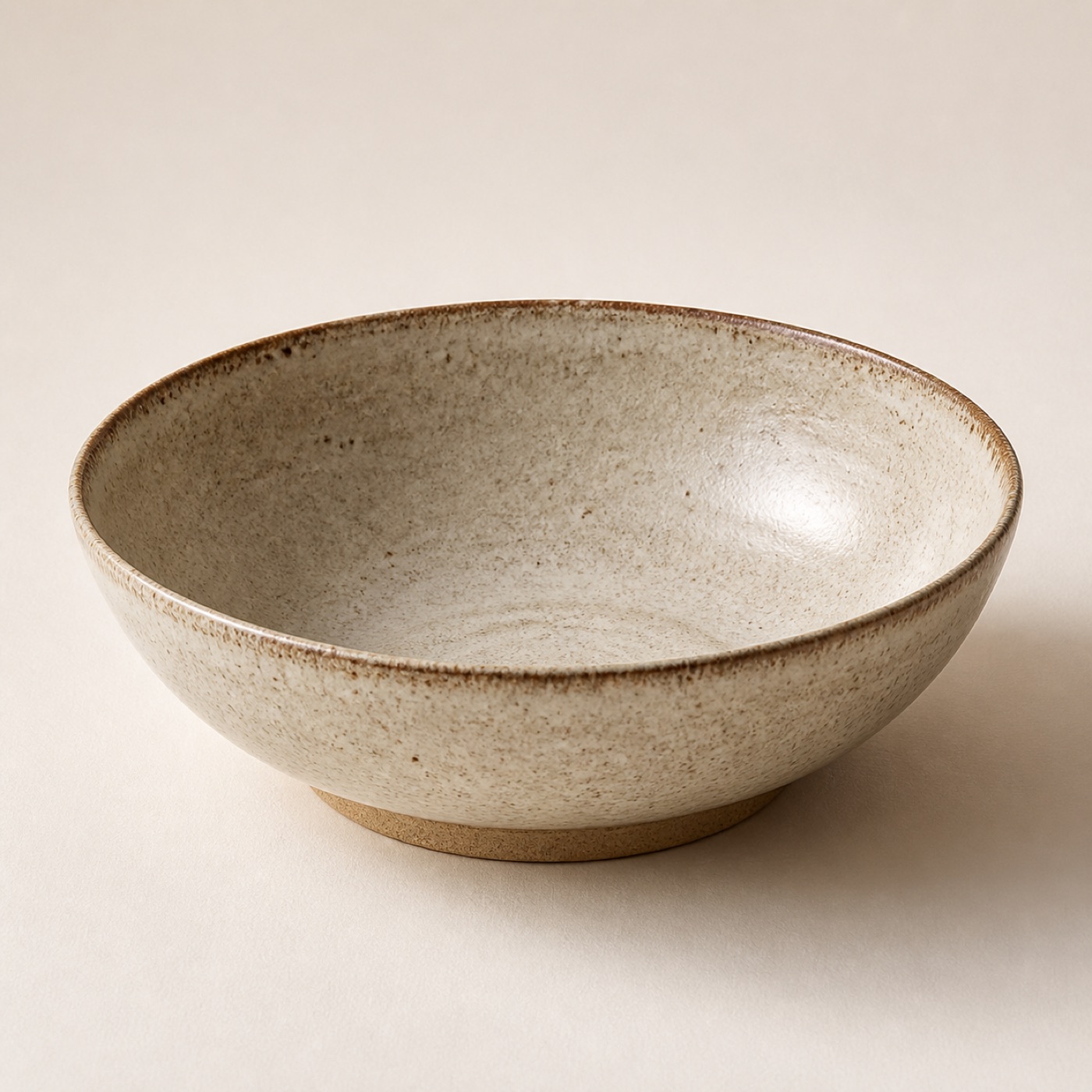A wide low stoneware serving bowl in an oatmeal glaze